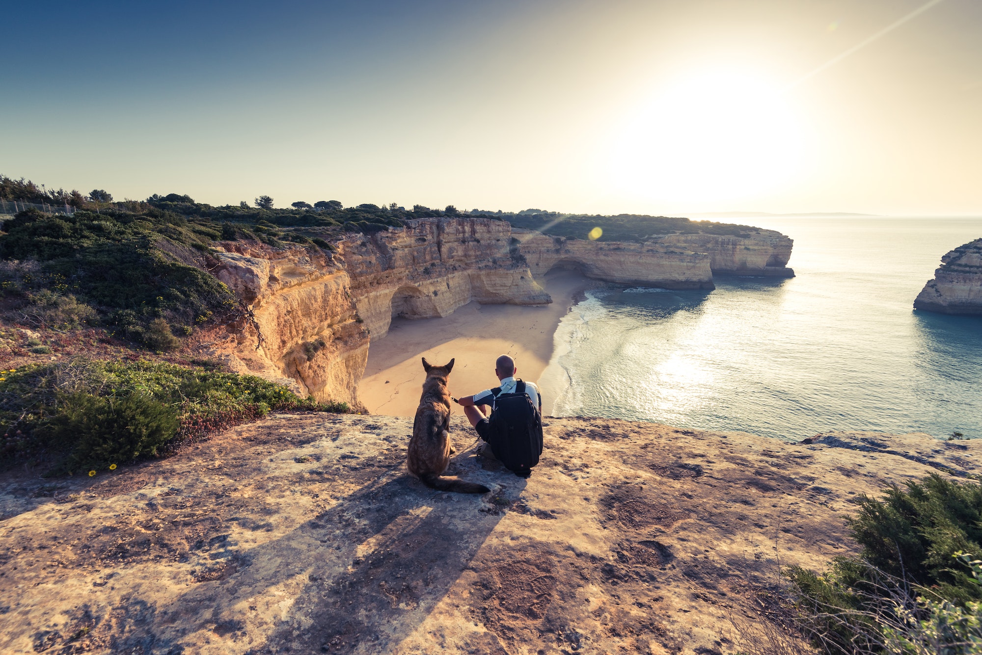 Best friends travellers sitting at cliffs in Portugal