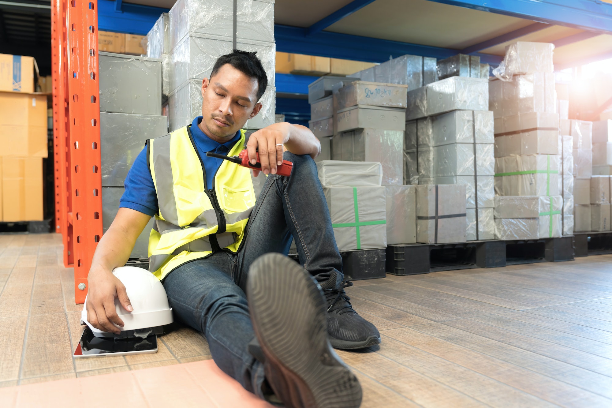 logistic worker man stress sit in warehouses worried, exhausted from overwork and cheap wages as the