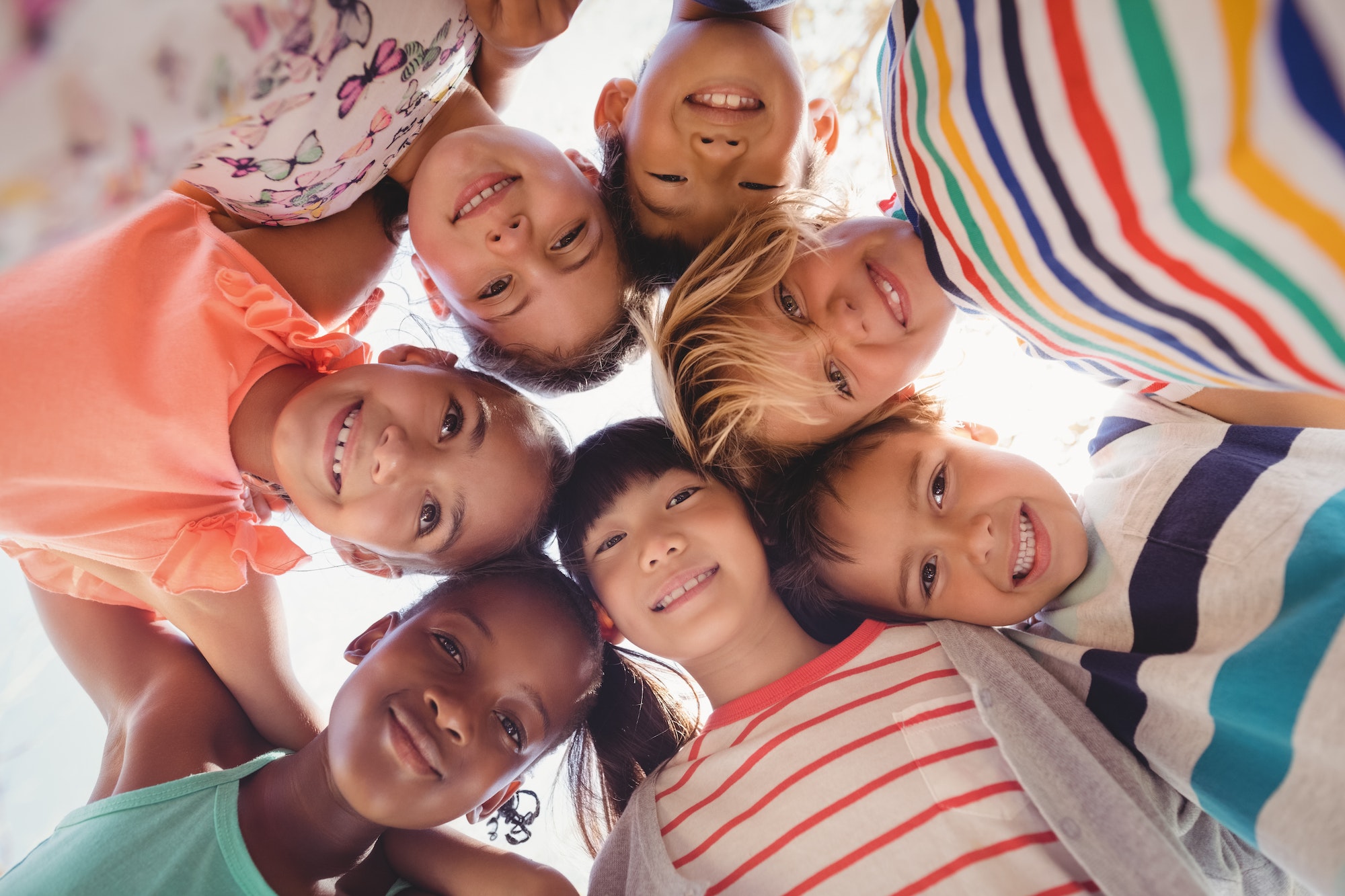 Portrait of schoolkids forming huddle