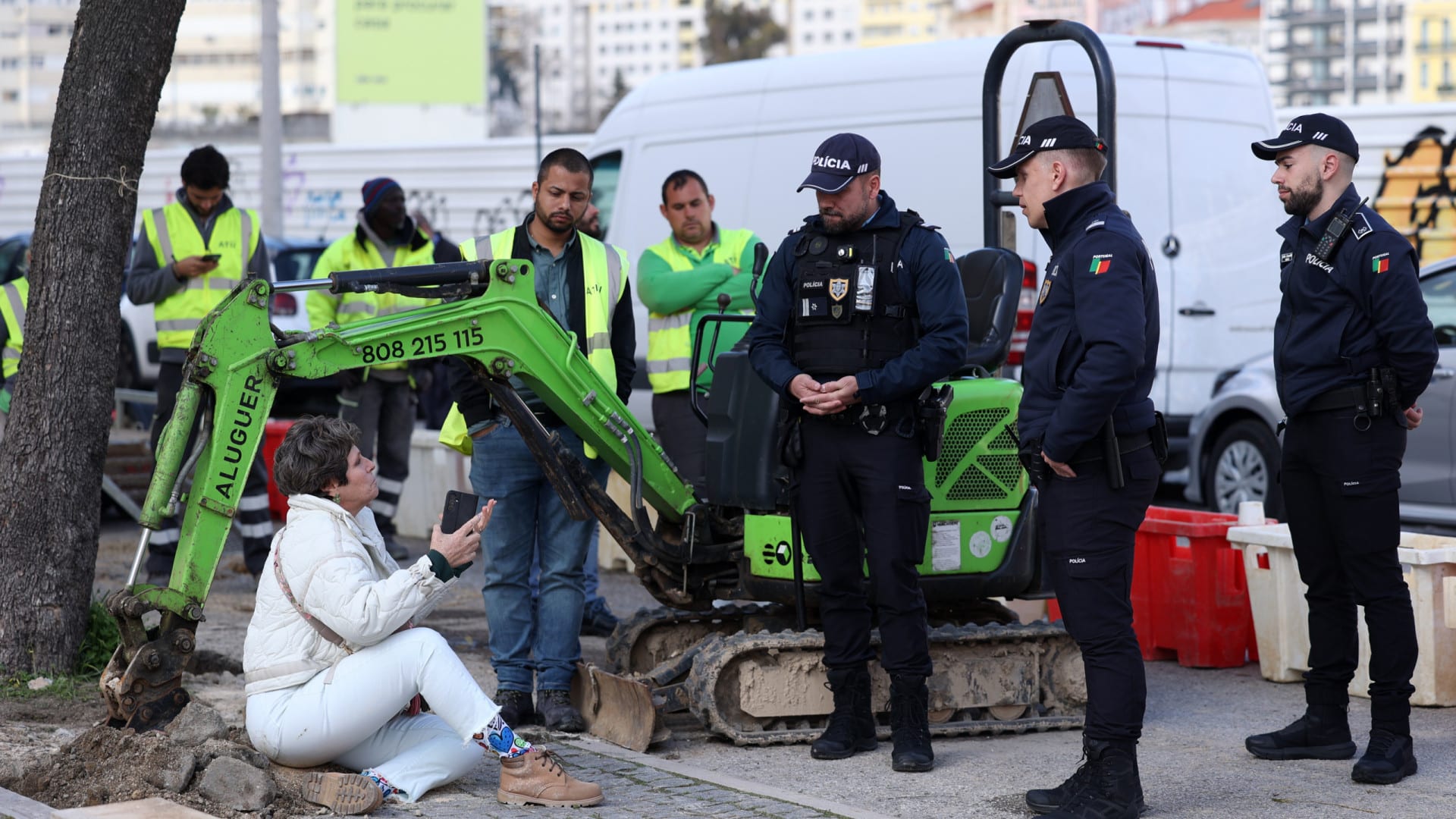 Une femme s'assoit près d'un jacaranda pour empêcher son enlèvement à Lisbonne.