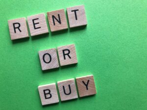 Rent or Buy in 3D wooden letters on a green background with copy space. Creative concept.