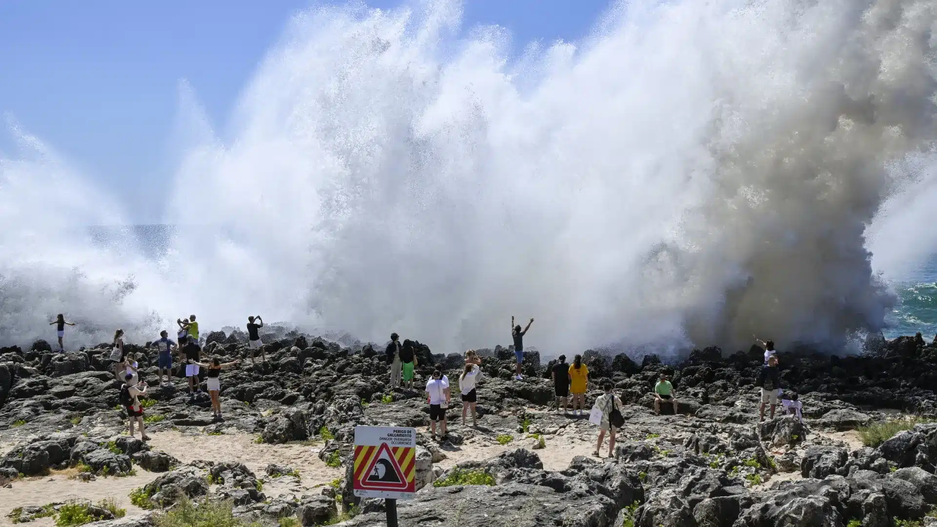 Les touristes affrontent l'agitation maritime pour la meilleure photo à la Boca do Inferno.