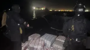 Des trafiquants lancent des ballots de drogue contre la Police Maritime lors d'une poursuite.