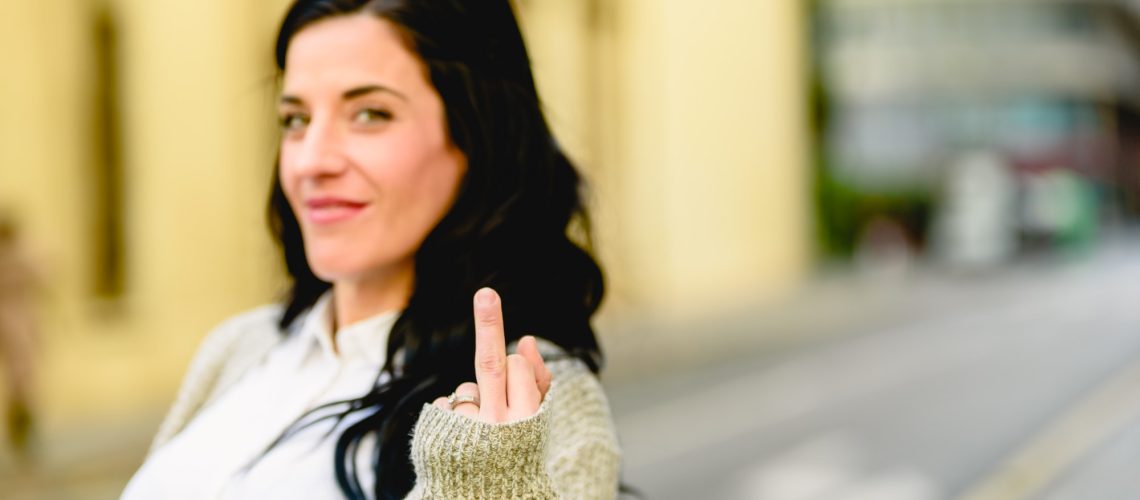 Woman showing middle finger as obscene and offensive insult.